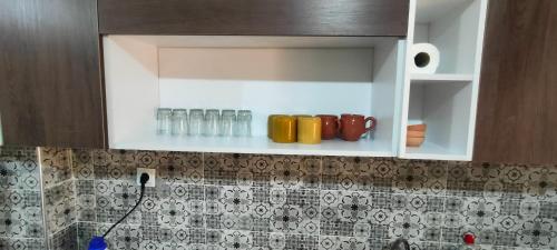 un placard avec des bouteilles et des verres sur un comptoir de cuisine dans l'établissement F4 Bahia cozy appart 140m2 3 balcon strategic spot, à Oran