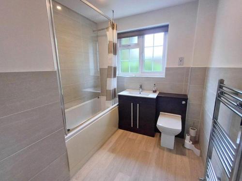 a bathroom with a toilet and a sink and a shower at Cute Cottage Style Getaway in Wilmslow in Handforth