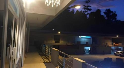 a balcony of a building at night with a chandelier at The Second Room in Ranau