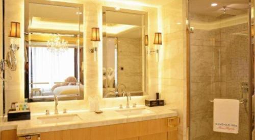 ZhangzhouにあるWyndham Grand Plaza Royale Mingfa Zhangzhouのバスルーム(洗面台2台、鏡、シャワー付)