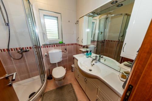 Un baño con lavabo, inodoro y ducha. en Apartment Eva, en Klimno