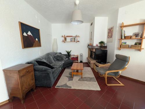 a living room with a couch and a tv at Casa Stocke - Relax e natura in Contrà Zocchi in Asiago