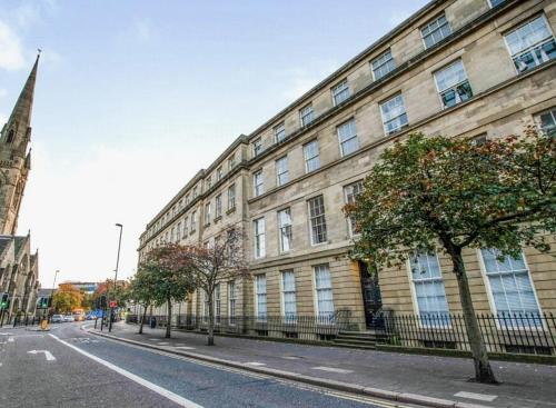 a large building on the side of a street at Central Newcastle Apartment - 3 Min Walk to Train Station and Attractions in Newcastle upon Tyne
