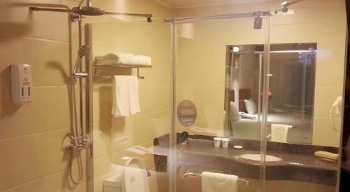 a bathroom with a glass shower with a sink at GreenTree Inn Hebei Langfang Bazhou Railway Station West Yingbin Road Express Hotel in Bazhou