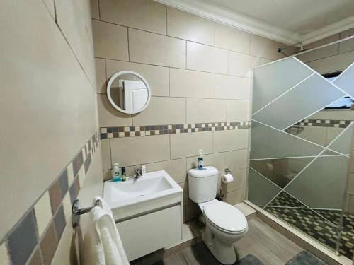 a bathroom with a toilet and a sink and a shower at Rolem Guest House in Fontainebleau