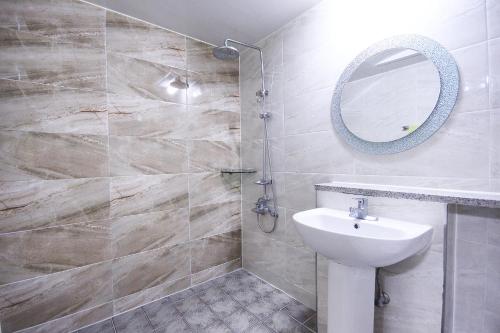 une salle de bain avec un lavabo et un miroir dans l'établissement Andong W Motel, à Andong