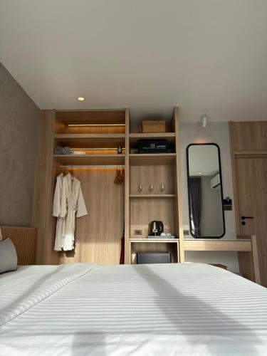 a bedroom with a white bed and a mirror at MJ Boutique Hotel Khao Lak in Khao Lak