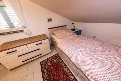 Un dormitorio con una cama y una cómoda y una ventana. en Apartment Eva, en Klimno