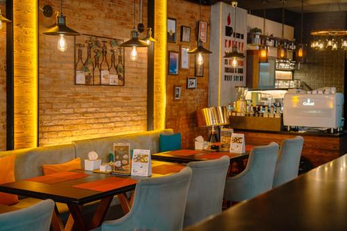 a restaurant with tables and chairs and a counter at The Printing House Poshtel in Bangkok