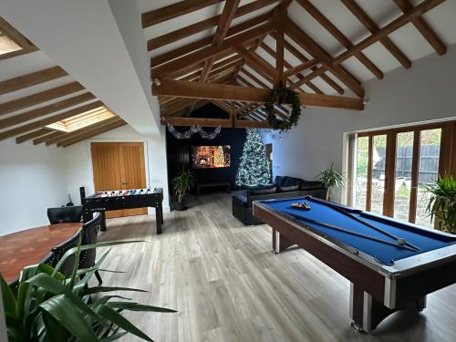 ein Wohnzimmer mit einem Billardtisch und einem Kamin in der Unterkunft The Old stables Barn in Old Hurst