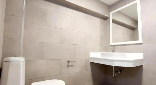 a white bathroom with a sink and a toilet at Tiny Krabi Hotel in Ban Ta Kun