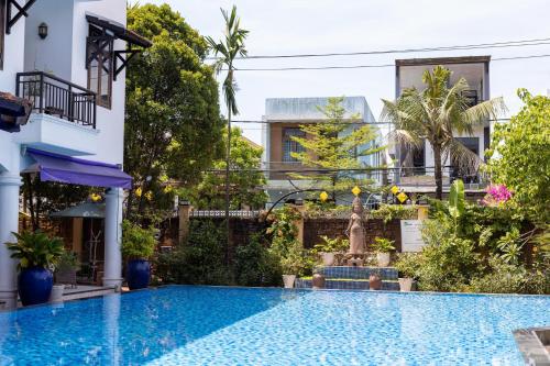 a swimming pool in front of a building at Khách sạn Le Domaine De Cocodo in Hue