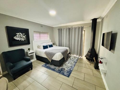 a bedroom with a bed and a chair at Rolem Guest House in Fontainebleau