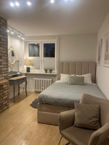 a bedroom with a bed and a desk and a couch at Apartament The Space 2 in Drawsko Pomorskie