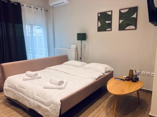 a bedroom with a bed with towels on it at Hodos Luxury APT 2 near ATH-Airport in Markopoulo