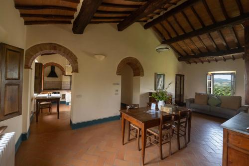 a kitchen and living room with a table and chairs at Le Sorbelle D'Orcia in Pienza