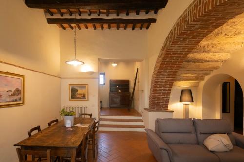 a living room with a table and a couch at Le Sorbelle D'Orcia in Pienza