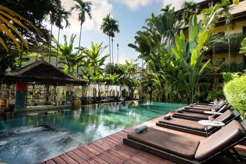uma piscina com espreguiçadeiras e um resort em Residence Indochine d'Angkor em Siem Reap