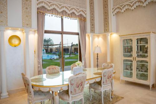 a dining room with a table and chairs and a window at Western Hotel - Madinat Zayed in Madīnat Zāyid