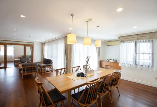 una sala da pranzo e un soggiorno con tavolo e sedie in legno di Baan Sawasdee Residence a Bangkok