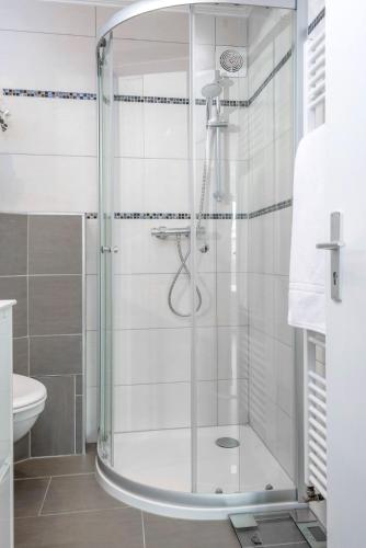 a shower with a glass door in a bathroom at Studio des roses place des Martyrs hyper centre in Luxembourg