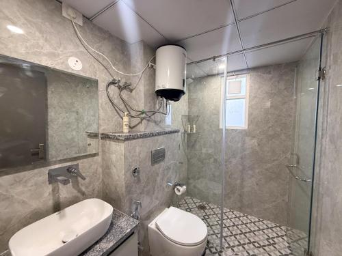 une salle de bain avec une douche, des toilettes et un lavabo dans l'établissement BedChambers Luxurious Aparthotel Near Medicity, à Gurgaon