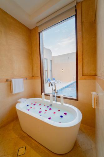 a bath tub in a bathroom with a window at Western Hotel - Madinat Zayed in Madīnat Zāyid