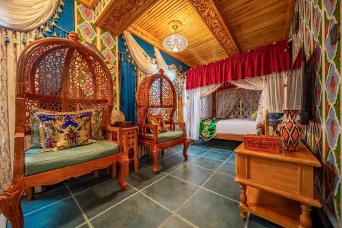a bedroom with two beds and chairs in a room at Wusong Guyi Western Regions Designer Courtyard in Yining