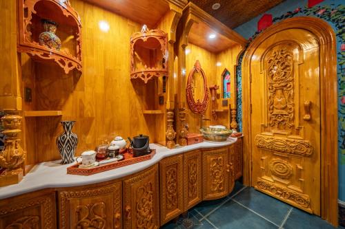 a bathroom with wooden cabinets and a mirror at Wusong Guyi Western Regions Designer Courtyard in Yining