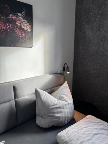 a couch with a white pillow in a room at HunsrückGlück Ferienhaus am Schinderhannes-Radweg in Lingerhahn