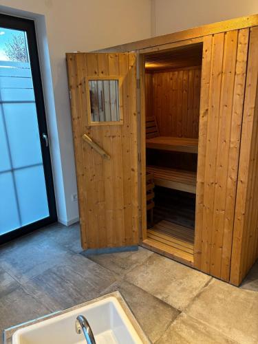 a bathroom with a sink and a wooden closet at HunsrückGlück Ferienhaus am Schinderhannes-Radweg in Lingerhahn