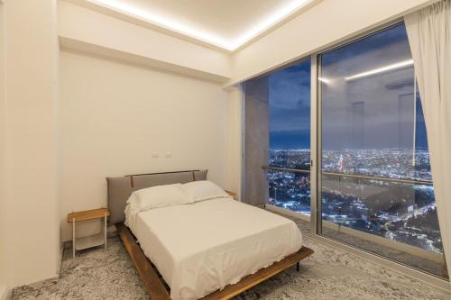a bedroom with a bed and a large window at Luxury Penthouse with Jacuzzi & Views in Puebla