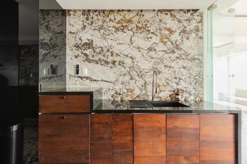 a kitchen with a sink and a stone wall at Luxury Penthouse with Jacuzzi & Views in Puebla
