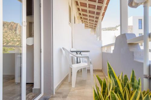 a room with a table and a chair on a balcony at Ostria Rooms in Palaiochora