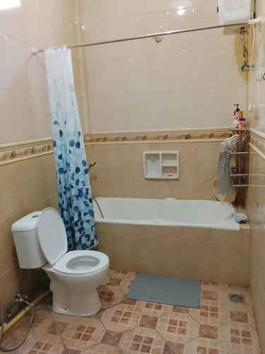 a bathroom with a toilet and a bath tub at Kuta Grace house Bali in Kuta