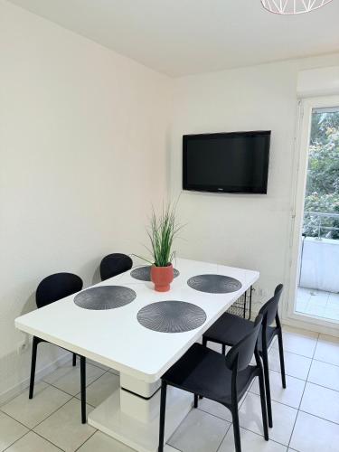 a white dining room with a white table and chairs at T2 Pineuilh avec parking privé in Pineuilh