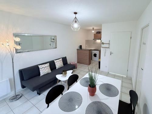 a living room with a couch and a table at T2 Pineuilh avec parking privé in Pineuilh