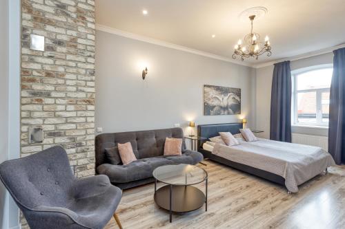 a living room with a bed and a couch at Apartments Vitenberg in Cēsis