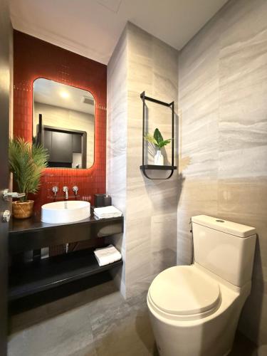 a bathroom with a toilet and a sink and a mirror at Edge central Pattaya by kansiree in Pattaya