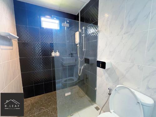 een badkamer met een douche, een toilet en een telefoon bij B.leaf in Ban Hup Kaphong