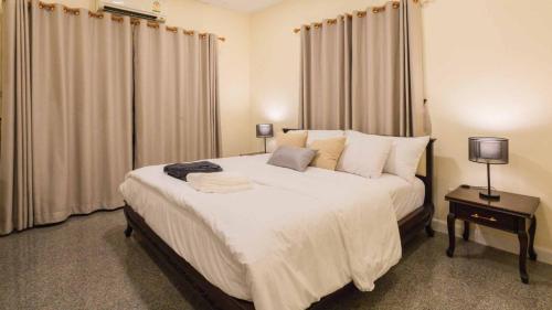 a bedroom with a large white bed with curtains at Poolnest Villa Aonang Tranquil Private Retreat in Krabi town