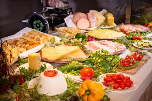 Una mesa llena de diferentes tipos de quesos y verduras. en AMASEA Resort, en San Teodoro