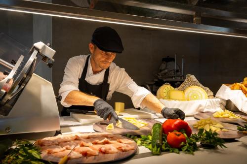 un hombre está preparando comida en una cocina en AMASEA Resort, en San Teodoro