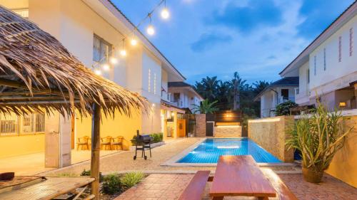an outdoor patio with a table and a swimming pool at Poolnest Villa Aonang Tranquil Private Retreat in Krabi town