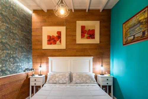 a bedroom with a white bed and two night stands at El Capricho de Rosmary in Villanueva