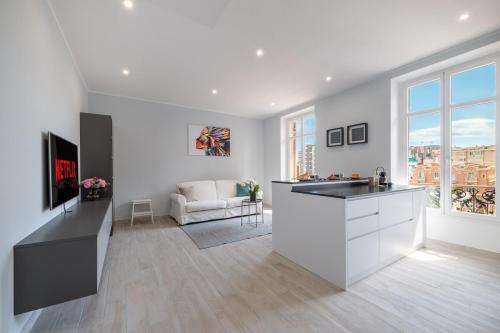 a kitchen and living room with a counter and a couch at Le COQ Charlene - Monaco à 50m - New in Beausoleil