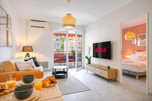 een woonkamer met een bank en een bed bij Le COQ Wagner - Garage -AC- Swimming pool in Menton