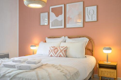 een slaapkamer met een groot wit bed met twee lampen bij Le COQ Wagner - Garage -AC- Swimming pool in Menton