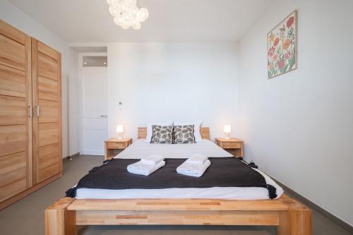 a bedroom with a large bed with two towels at Le COQ Jean Jaurès - Garage XL-AC- Monaco Border in Roquebrune-Cap-Martin