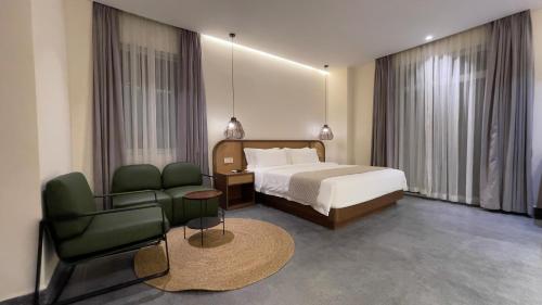 una habitación de hotel con una cama y una silla en Joya Hotel, en Phnom Penh
